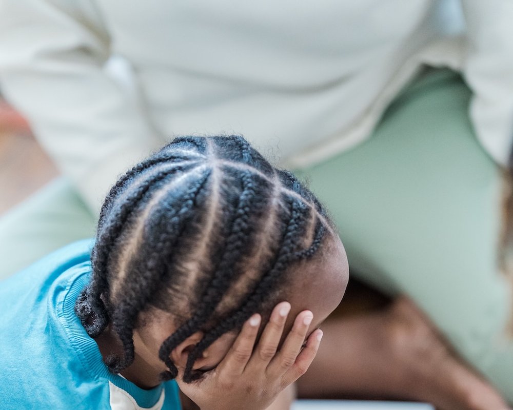 A young child being comforted by a trusted adult, representing the safe, supportive space Debbie creates for children and young people